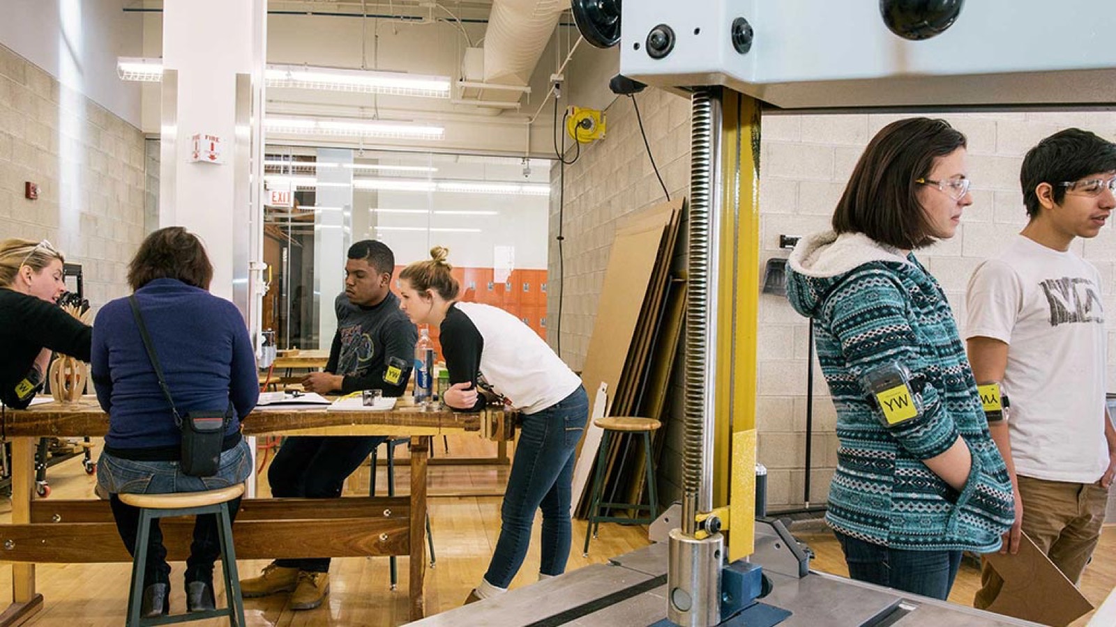 Group of makers talking around workbenches in a shared shop