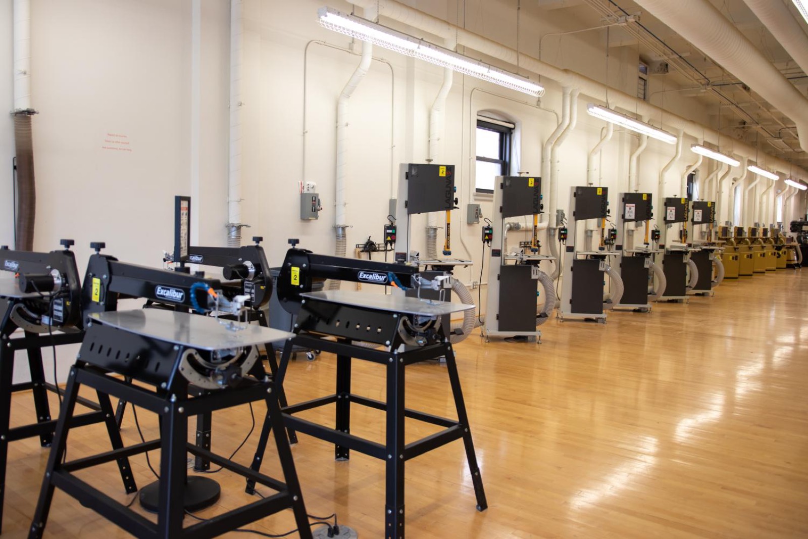 Row of production machines in a bright, high-ceilinged loft shop